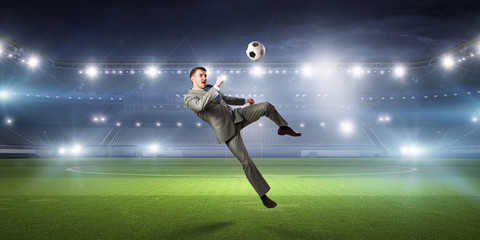 Fototapeta na wymiar Businessman playing soccer