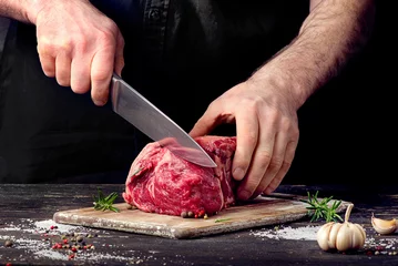 Fotobehang Vlees Man die rauw rundvlees snijdt