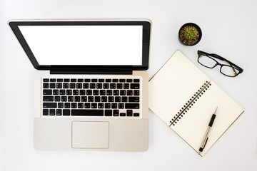 Modern White office desk table with blank screen laptop computer, pen,eyeglasses and leather notebook. Top view with copy space.Working desk table concept.