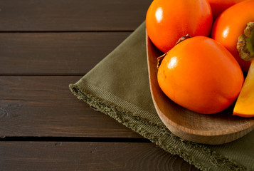 persimmons on wooden surface