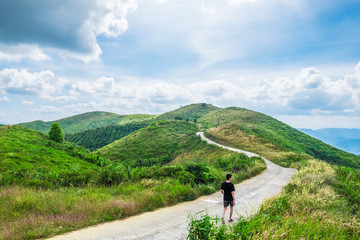 Man walking road way curve on mountain