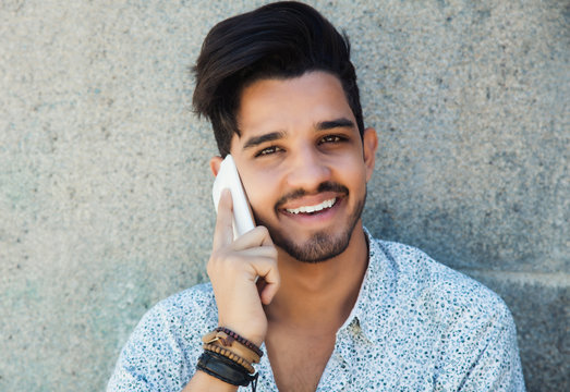 Handsome hipster with beard laughing at phone