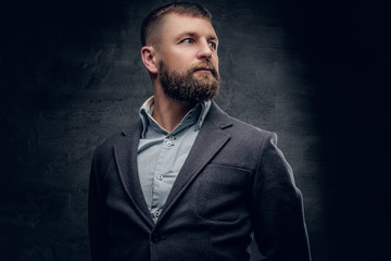 A bearded middle age male dressed in a woolen suit