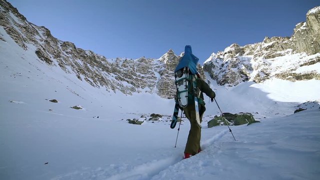 Two men carrying ski in winter mountains to the top.