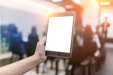 hand holding the smartphone on blurred image of people in confer