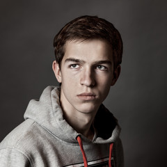 Portrait of handsome young man on gray background,