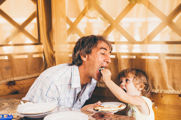 Child with father have a breakfast.