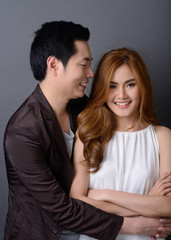 young lovely asian couple posing and smiling in studio for pre-w