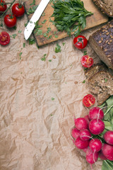 Kitchen background with baking paper, tomatoes, radish and parsley