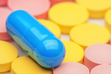blue medical pills lies on colored pills