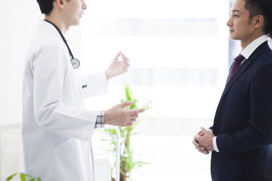 Businessman And Doctor Are Talking In The Examination Room