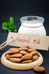 Almond with almond milk in glass with almond milk tag.