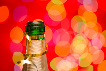 Champagne bottleneck with blurred lights in background New Year celebration