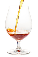 Pouring dark ale beer into a tulip glass  isolated