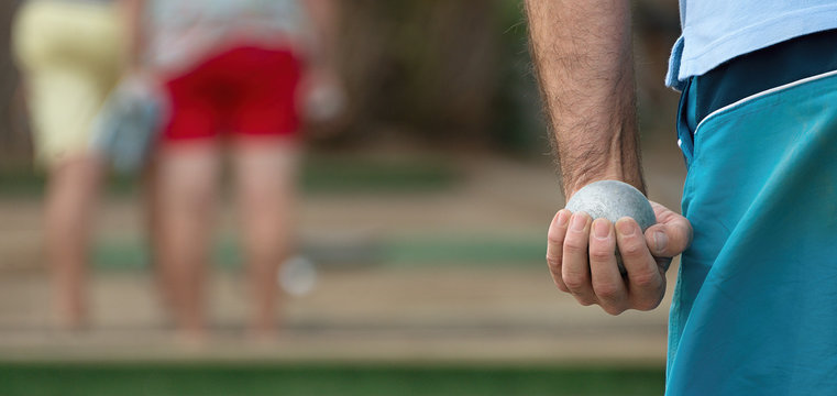 Senior playing petanque,fun and relaxing game.Petanque ball in hand of man