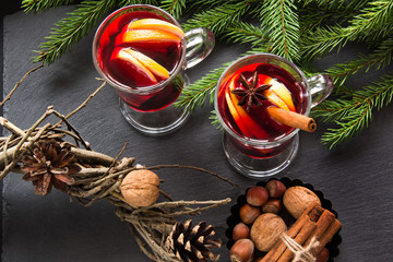 Hot Mulled wine with cinnamon and christmas tree on black slate dish. Top view and copy space.