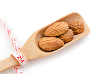 group of almonds in wooden scoop.