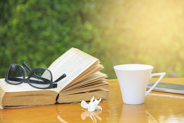 Stock Photo:.Close up glasses on book and Coffee on the table in