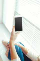 Woman with modern mobile phone in hands