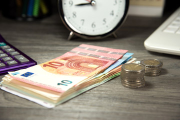 Ein Wecker und Geld in einem Büro