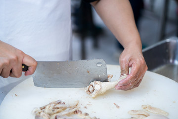 Man's hand cutting  chicken
