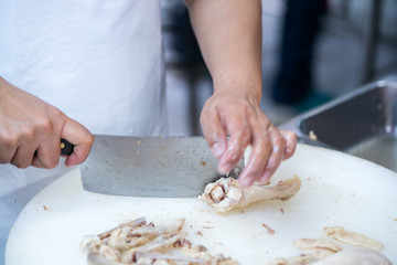 Man's hand cutting  chicken
