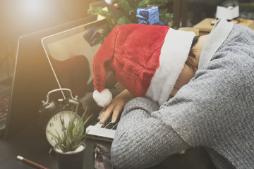 business woman with santa hat sleeping on desk office after christmas party and happy new year.