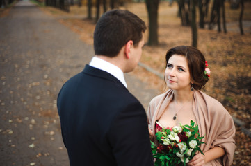 Couple walks in the park. Romantic embrace of newlyweds.