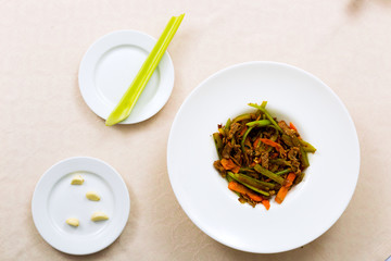 Meat fried with vegetables on the plate standing on the table