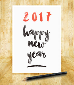 2017 happy new year on white paper frame with pencil in hand bru