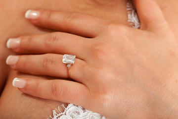 Young bride showing her ring with hand on her chest. Close up.
