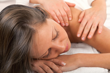 Fototapeta na wymiar Young woman having a classical massage lying on white bed. Detai