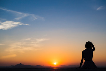 Silhouette of free woman enjoying freedom feeling happy at sunset. Serene relaxing woman in pure happiness