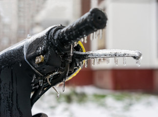 Handle of motorcycle covered with ice after freezing rain