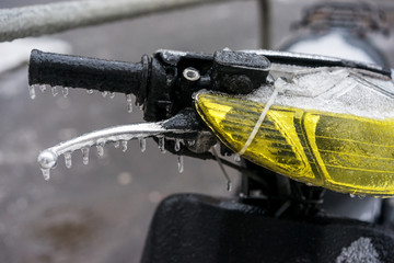Handle of motorcycle covered with ice after freezing rain