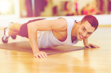 smiling man doing push-ups in the gym