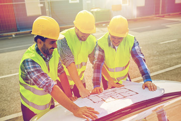close up of builders with blueprint on car hood