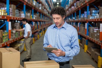 Obraz premium Warehouse worker using digital tablet