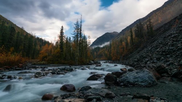 Movement of clouds over a small island in the mountainous river Akkem.The Republic of Mountain Altai, Russia. Autumn 2016