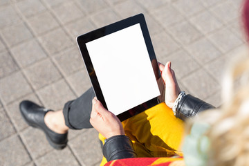 Woman sitting and using blank screen tablet