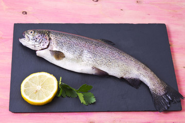 Trout with lemon and parsley on rose wood