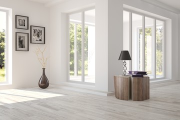 White room with modern furniture and green landscape in window. Scandinavian interior design
