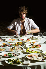 Handsome man eats at table