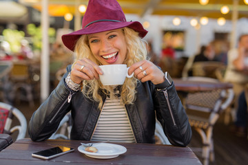 Happy woman enjoying her coffee at the cafe