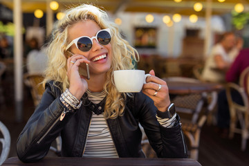 Woman sitting with sun glasses and talking on the phone
