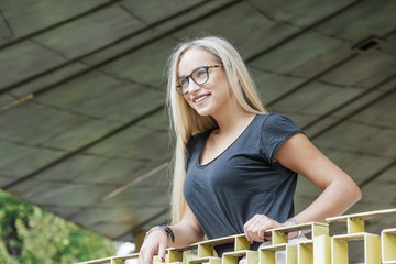 Fototapeta na wymiar portrait of a young woman, blonde, glasses, outdoors in the park