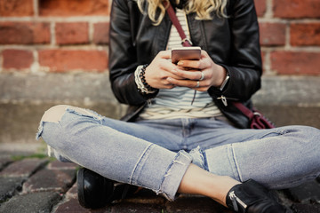 Woman sitting in lotuss position in cuty and using smartphone