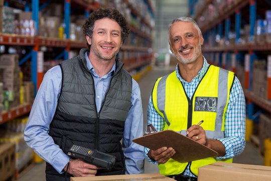Portrait of warehouse workers with clipboard 