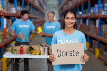 Portrait of happy volunteer holding sign boards with message 