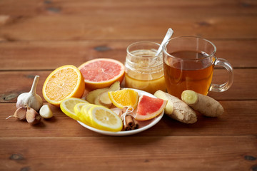 ginger tea with honey, citrus and garlic on wood